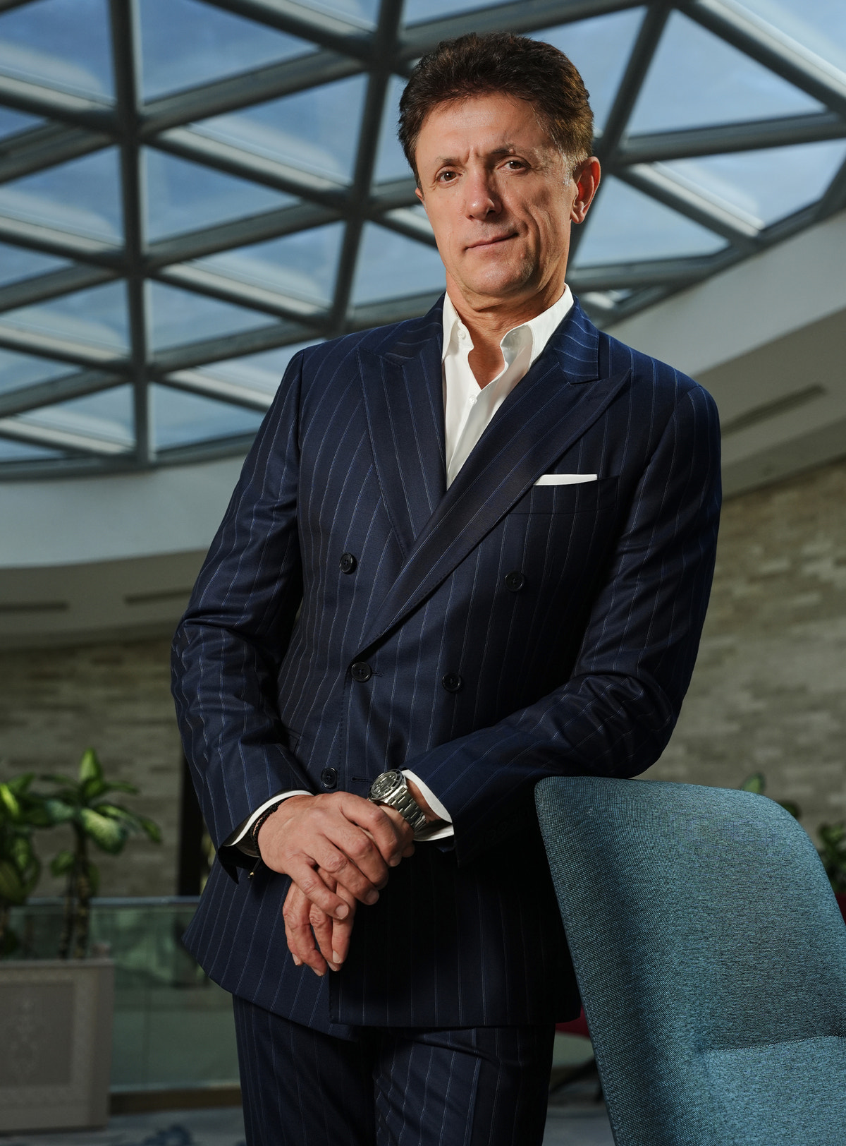 Navy pinstripe suit and white shirt in a glass-roofed interior