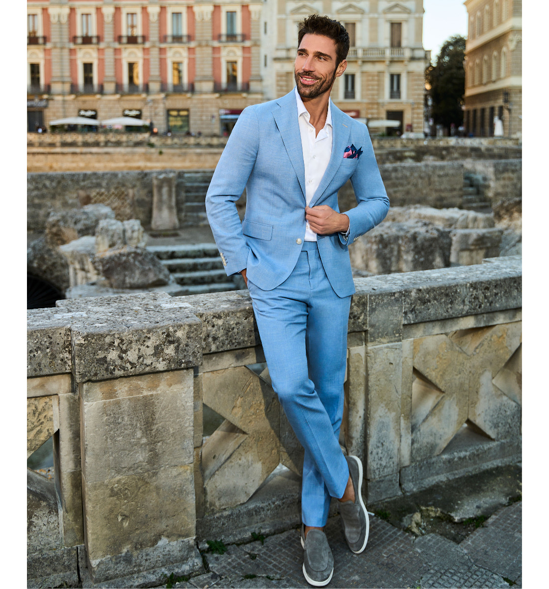 Light blue suit and white shirt beside a fountain