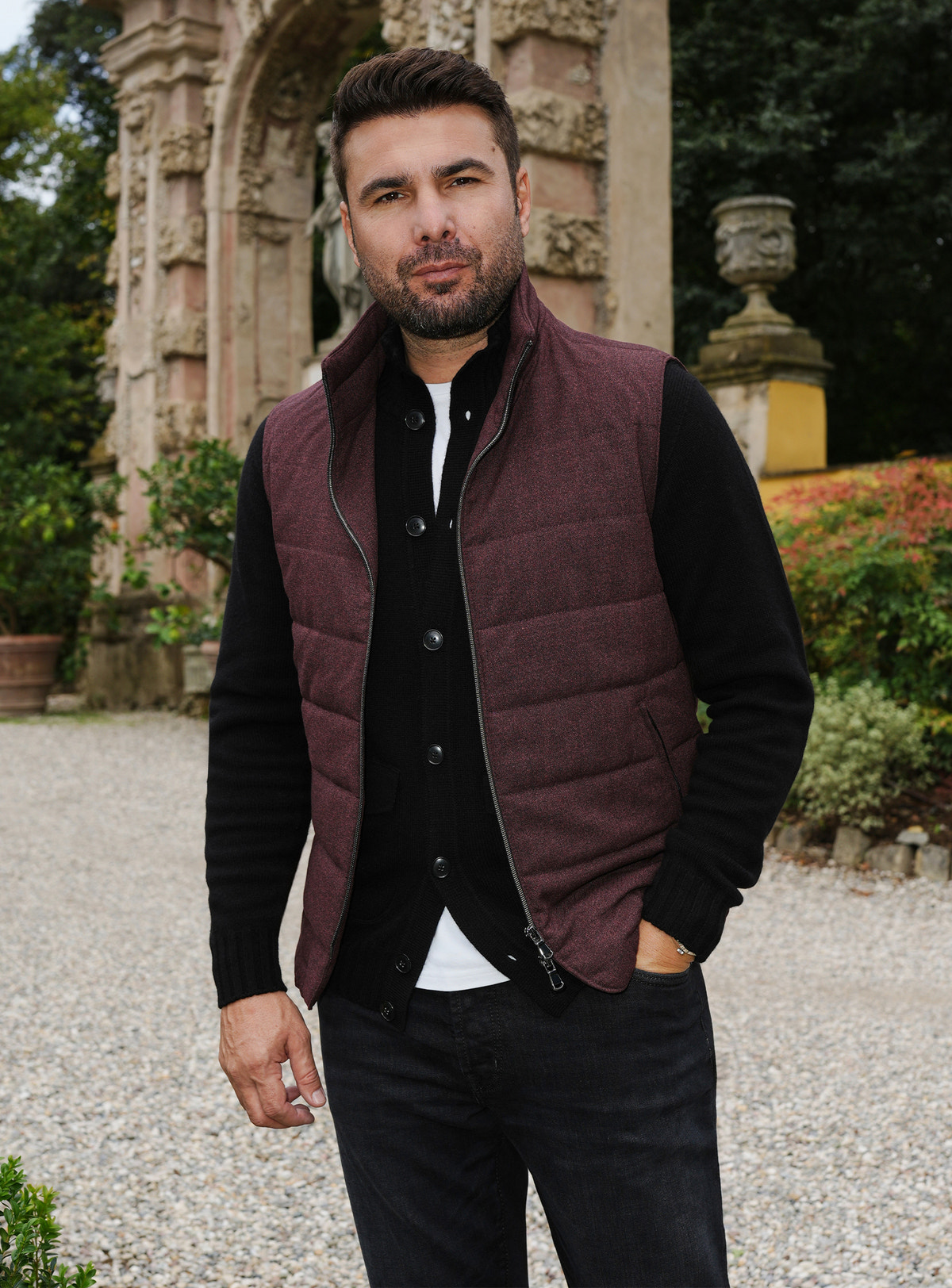 Burgundy quilted Consiglieri gilet layered over a black cardigan