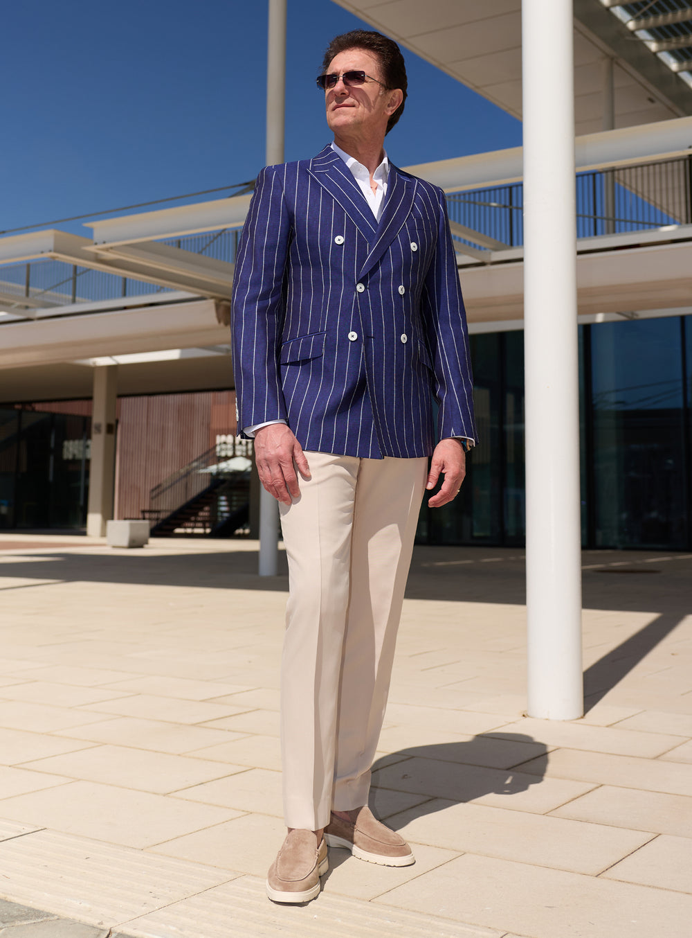 Navy double-breasted Consiglieri blazer with white stripes, worn with beige trousers