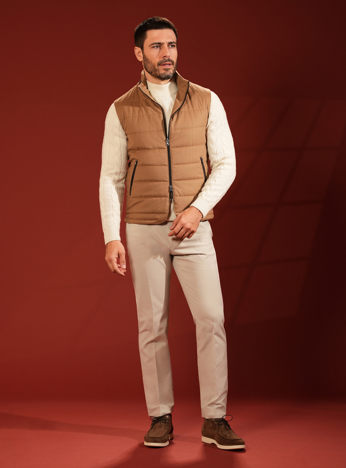 Camel quilted Consiglieri vest with an ivory sweater and light trousers