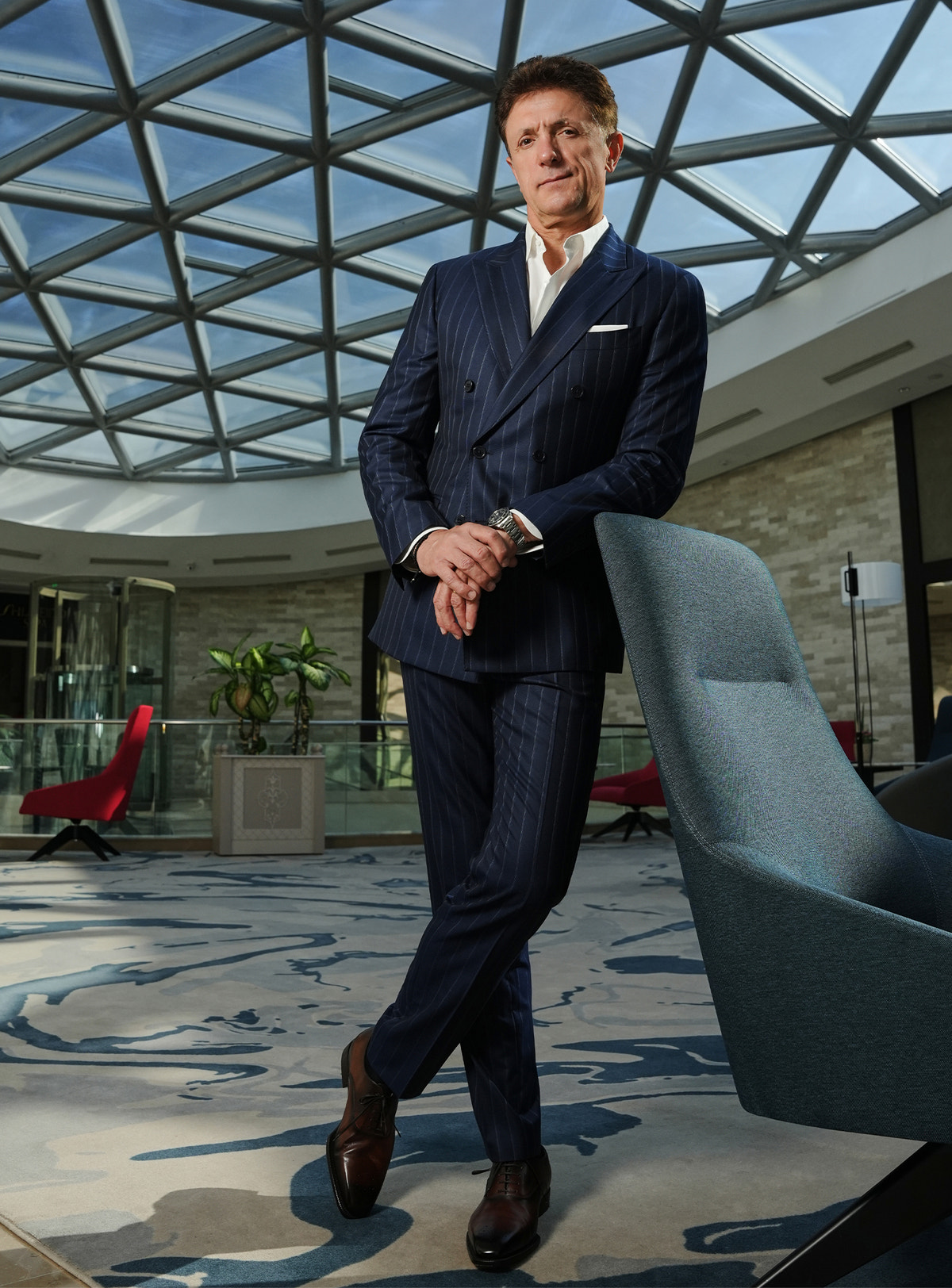 Navy pinstripe Consiglieri suit in a look with brown shoes