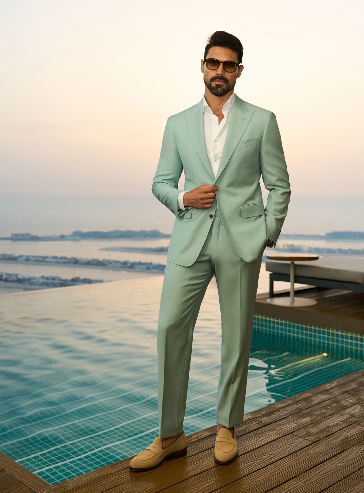 Consiglieri Sapphire Sophistication: mint green suit with a white shirt beside a pool
