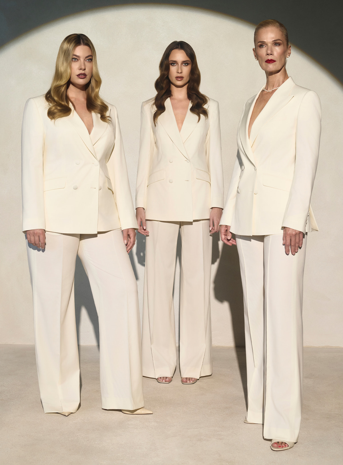 Three ivory Consiglieri DONNA suits with double-breasted blazers and wide-leg trousers