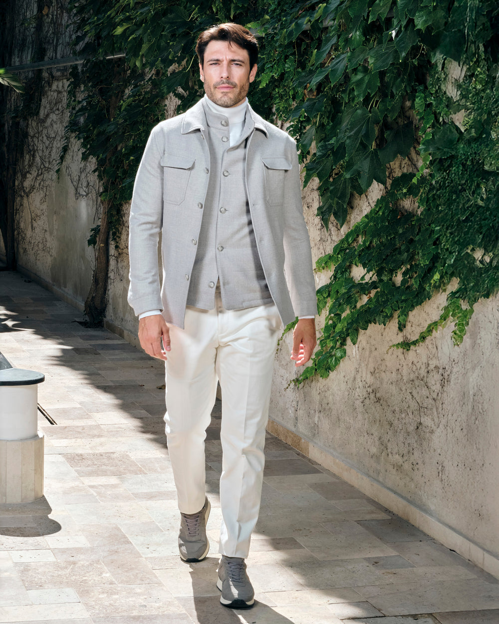 Beige Consiglieri patch-pocket jacket over a taupe cardigan and white trousers