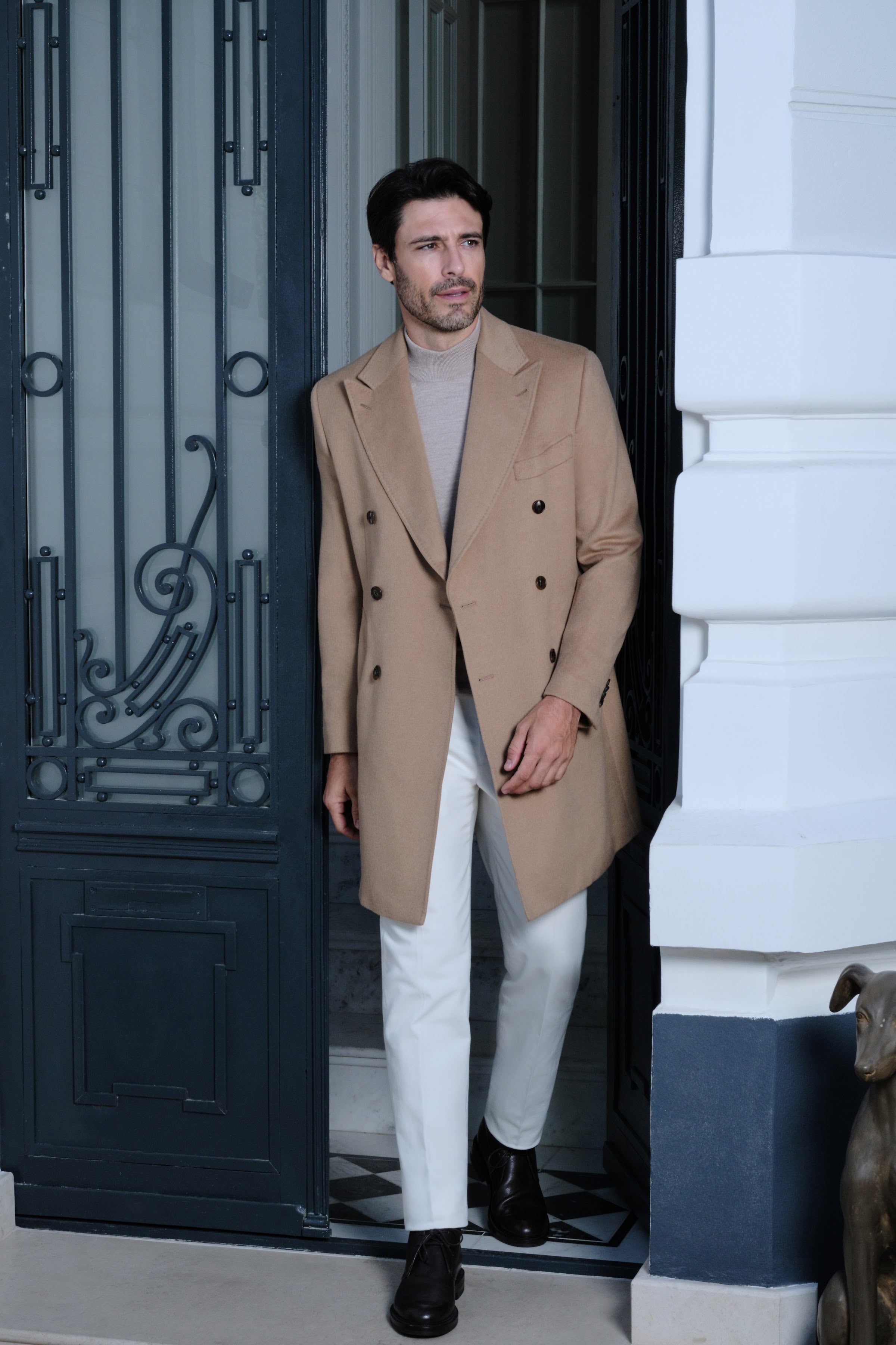 The camel Overcoat by Consiglieri, worn over fine knitwear in a relaxed early-autumn silhouette.
