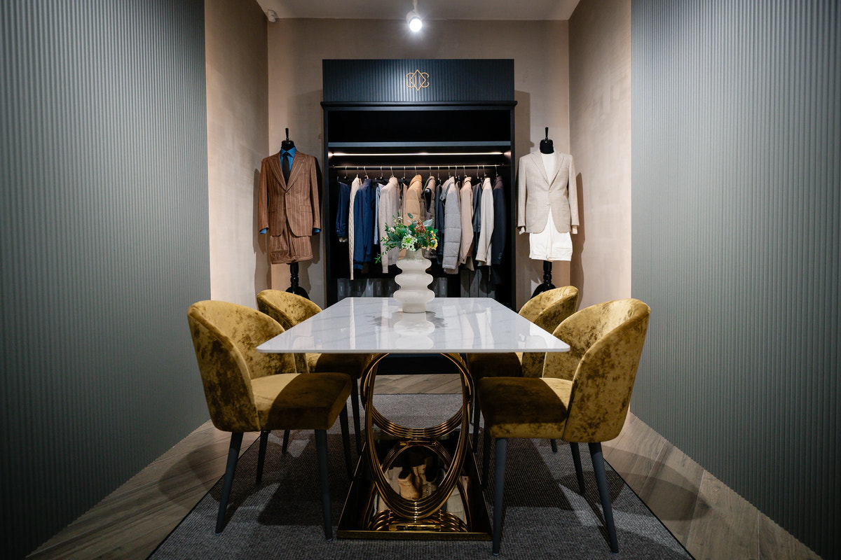A consultation room with a white table and outfits in neutral tones.
