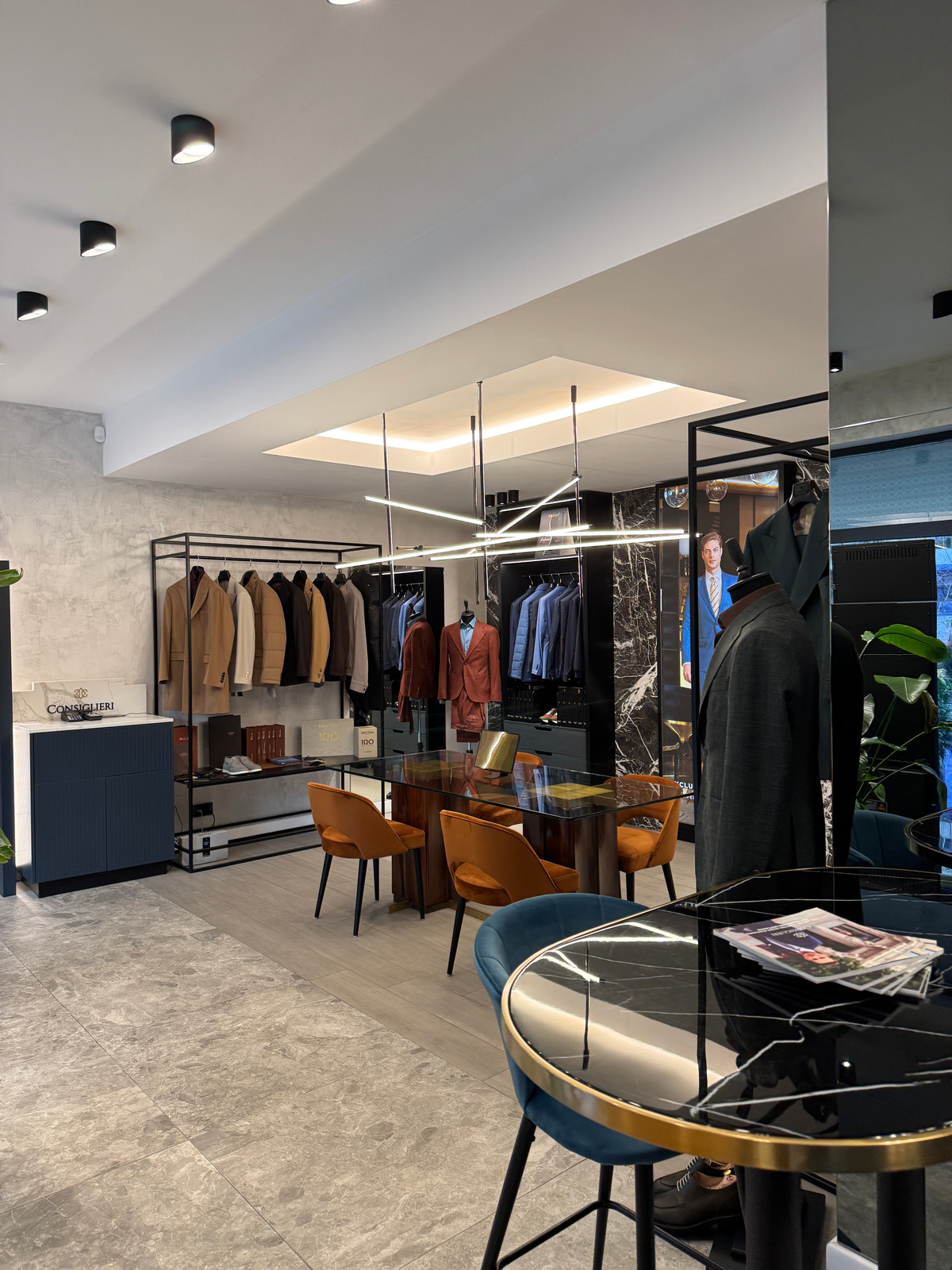 A corner of the showroom, with a blue chair and jacket displays in the background.