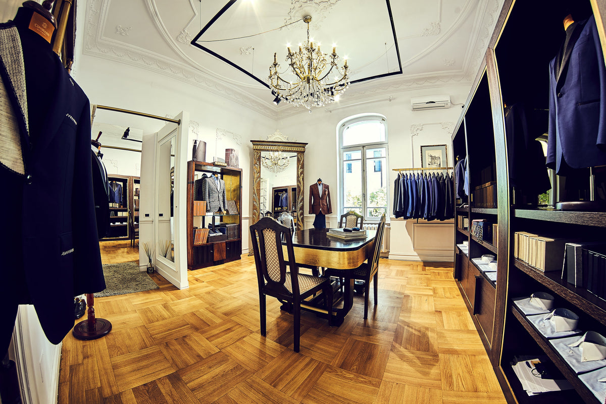 Consiglieri showroom with displayed jackets, dark furniture and a wooden floor
