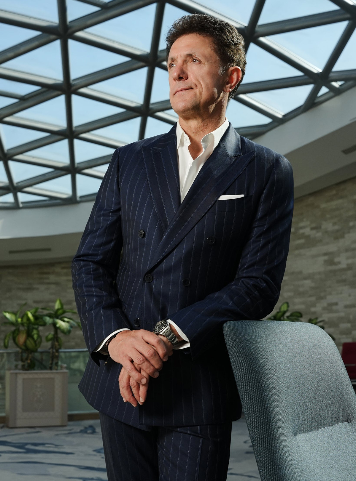 Navy pinstripe suit with a white shirt beneath a glass roof