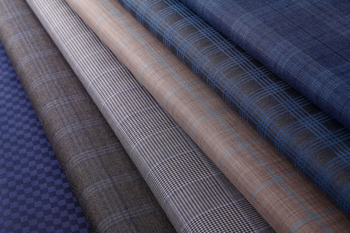Suiting fabrics in blue, grey and beige, with subtle stripes and checks