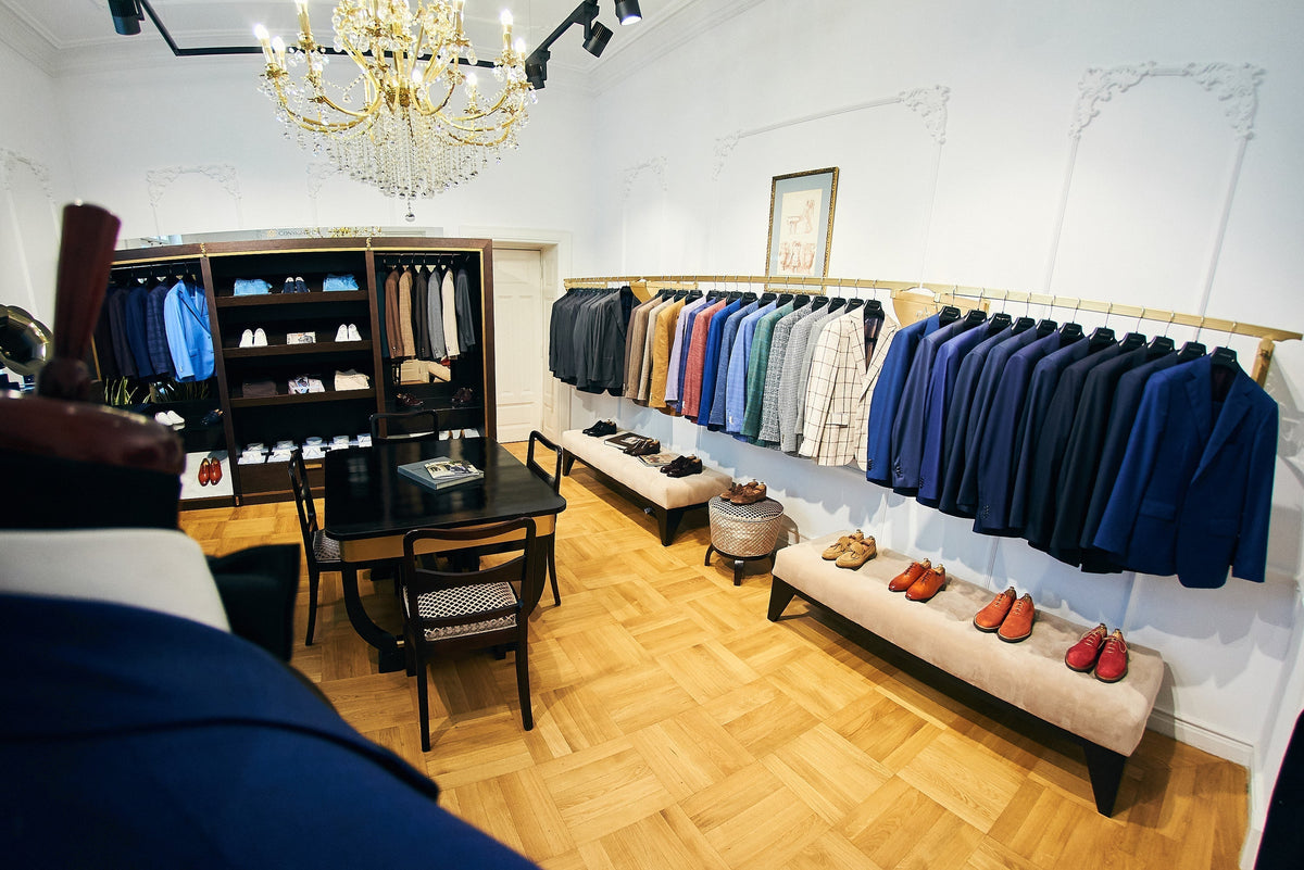 Navy, grey and beige jackets displayed with shirts and shoes in the Consiglieri showroom