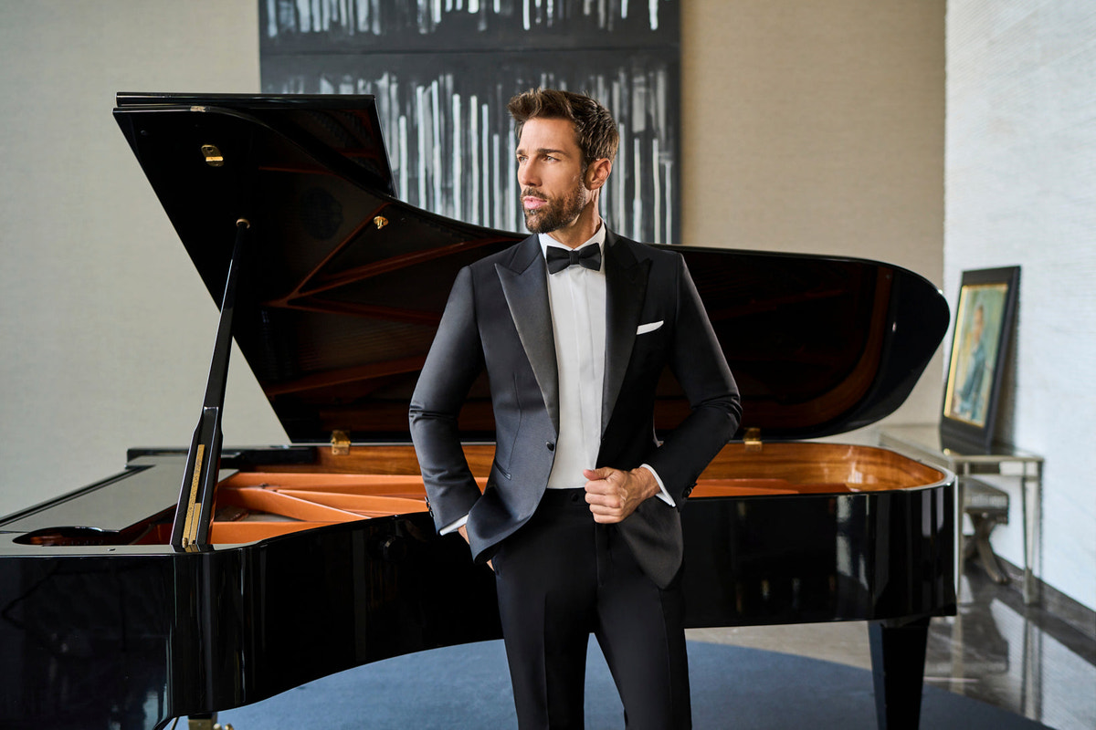 Formal ensemble with a bow tie beside a grand piano