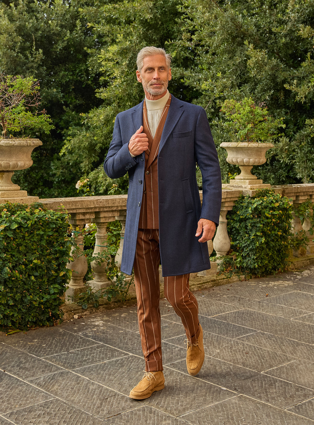 Consiglieri: navy overcoat over a cognac striped suit and ivory roll-neck