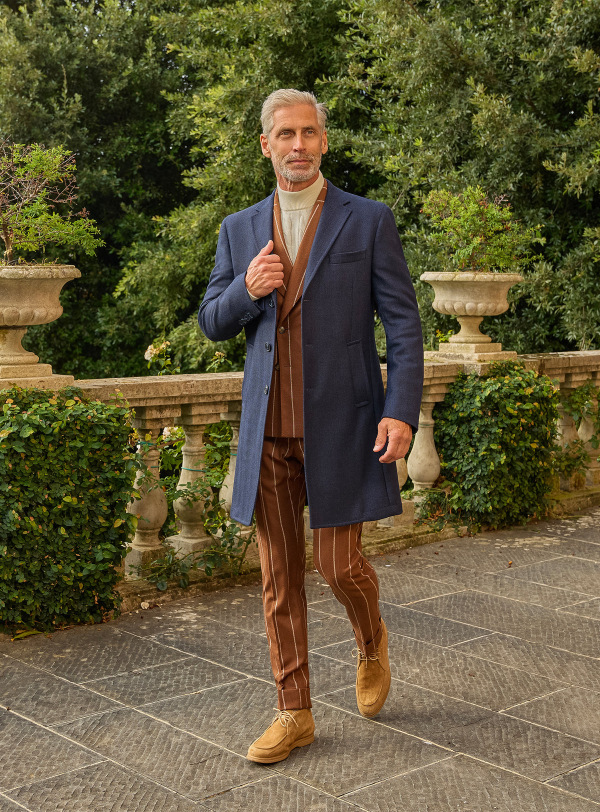 Consiglieri: navy overcoat over a cognac striped suit and ivory roll-neck