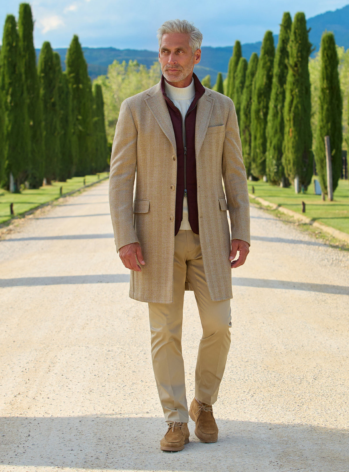 Consiglieri: camel overcoat with a contrasting burgundy collar and cream trousers