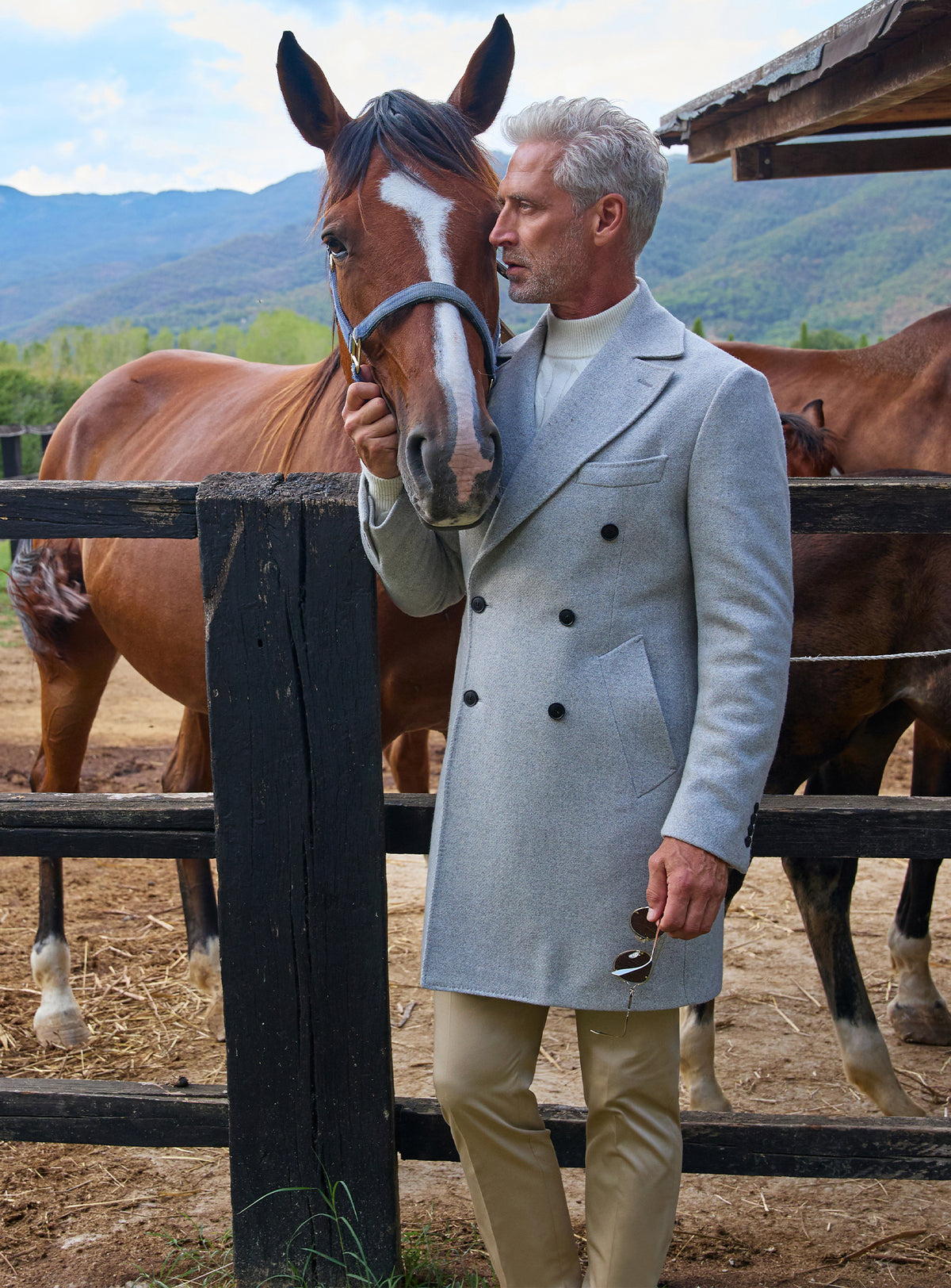Consiglieri: light grey double-breasted overcoat worn beside a horse