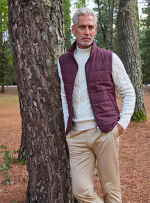 Consiglieri: ivory cable-knit sweater beneath a burgundy quilted gilet