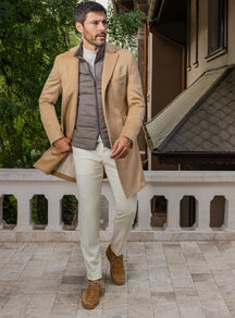 Consiglieri: camel overcoat over a taupe quilted gilet, with cream trousers