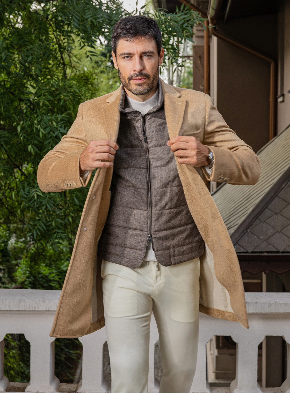 Consiglieri: camel overcoat over a taupe quilted gilet, with cream trousers