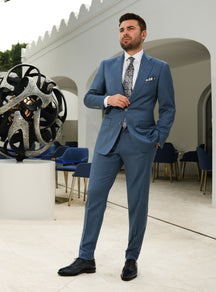 Muted blue Consiglieri suit with notch lapels, a white shirt and patterned tie