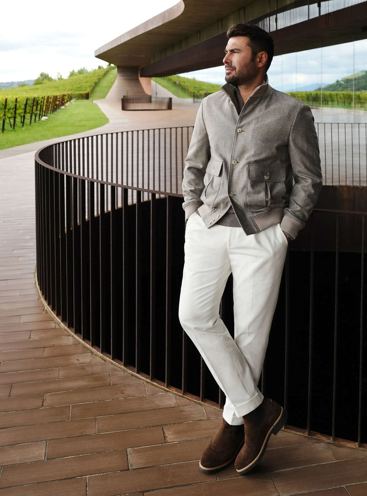 Grey Consiglieri bomber jacket with flap pockets, worn with white trousers