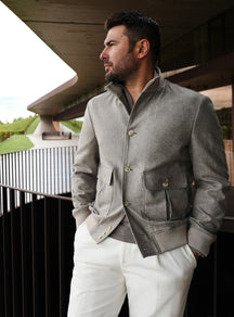 Grey Consiglieri bomber jacket with flap pockets, worn with white trousers