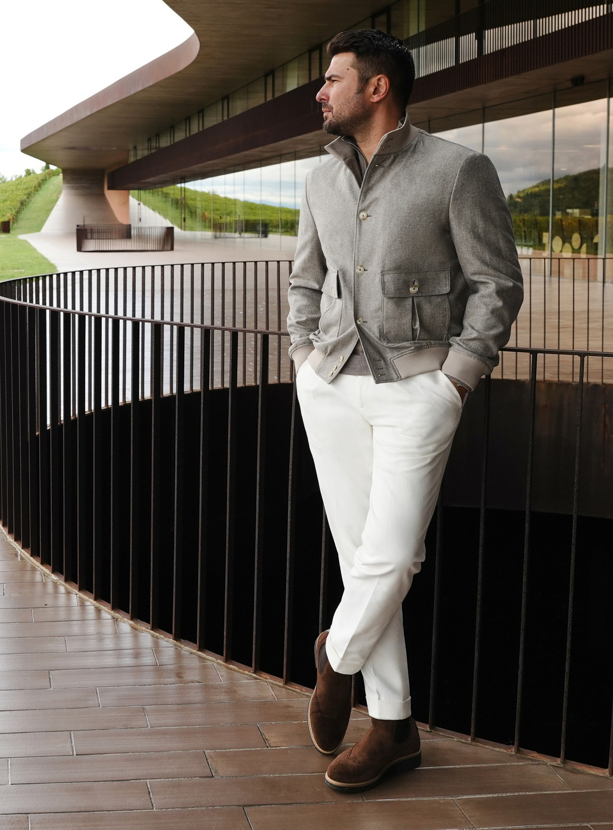 Grey Consiglieri bomber jacket with flap pockets, worn with white trousers
