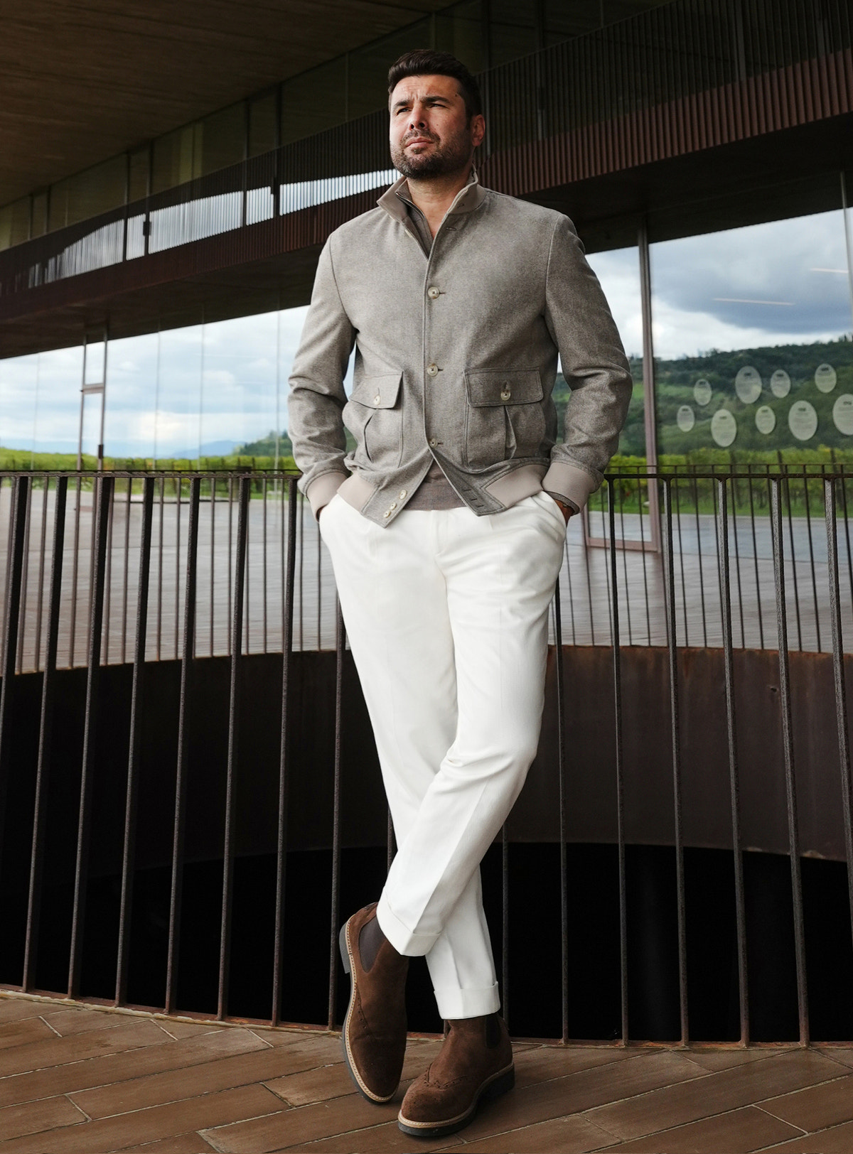 Grey Consiglieri bomber jacket with flap pockets, worn with white trousers