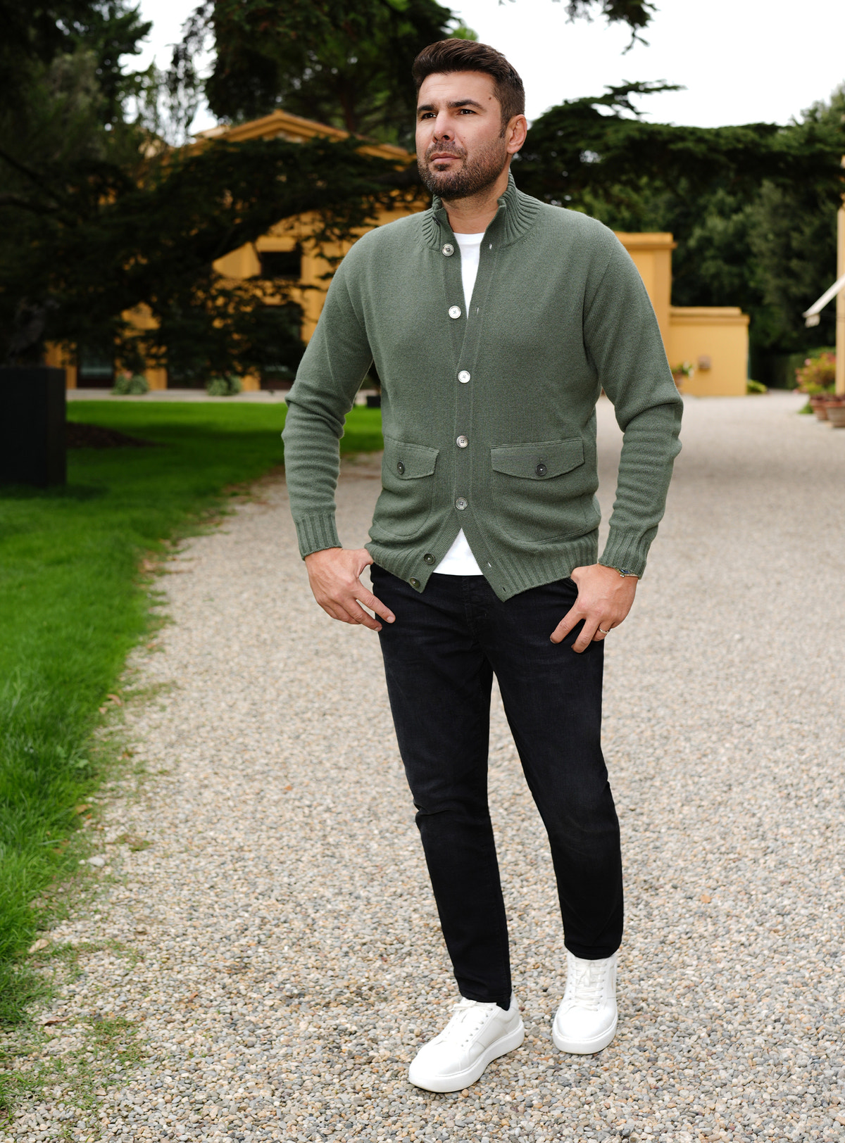 Black Consiglieri jeans with a sage green cardigan and white sneakers