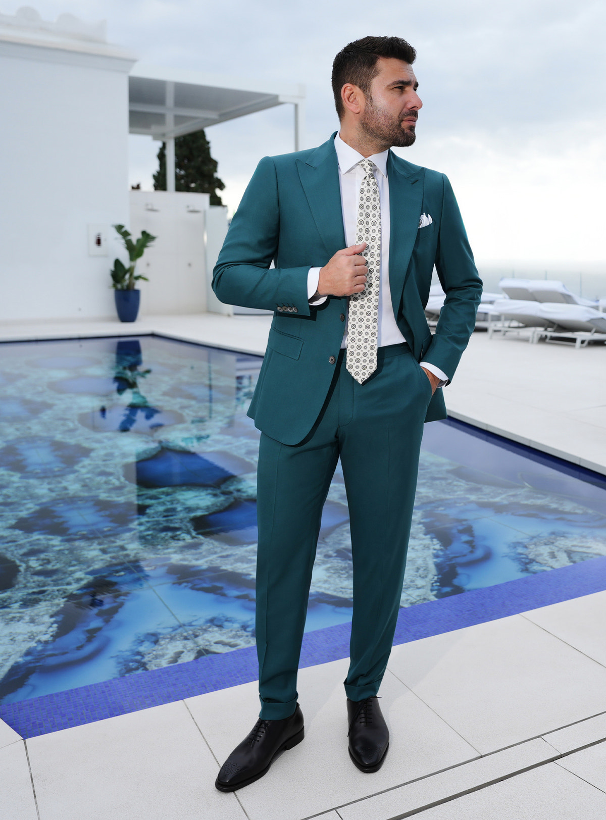Teal Consiglieri suit worn with a white shirt and a light patterned tie