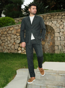 Dark green Consiglieri suit casually styled with a white T-shirt and brown loafers