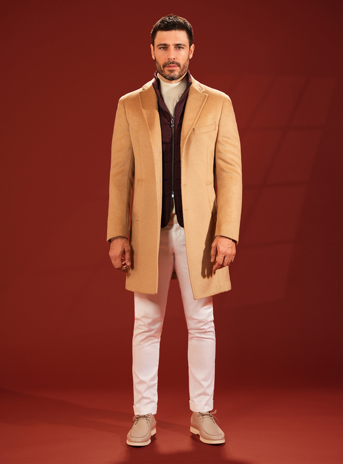 Camel Consiglieri overcoat worn with white trousers and beige footwear
