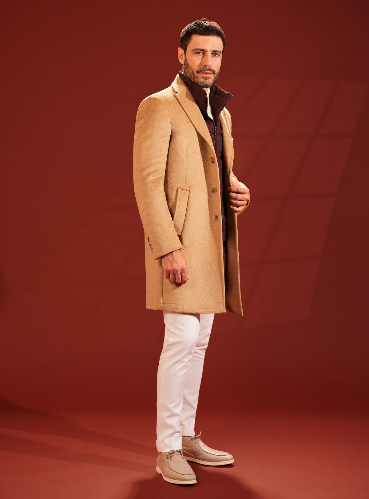 Camel Consiglieri overcoat worn with white trousers and beige footwear