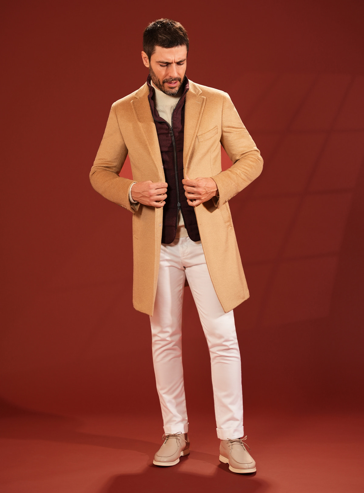 Camel Consiglieri overcoat worn with white trousers and beige footwear