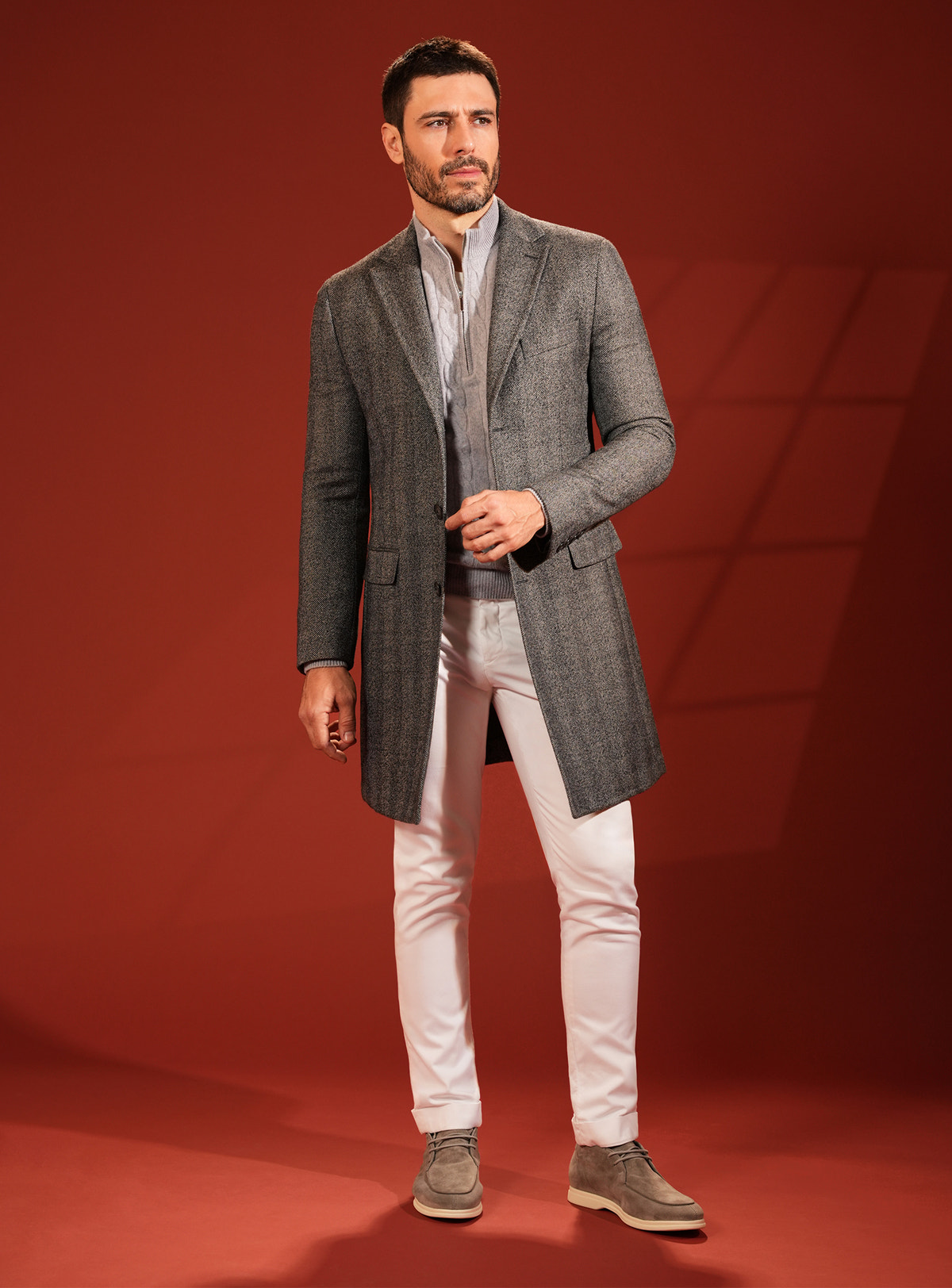 Dark grey Consiglieri overcoat with white trousers and neutral-toned footwear