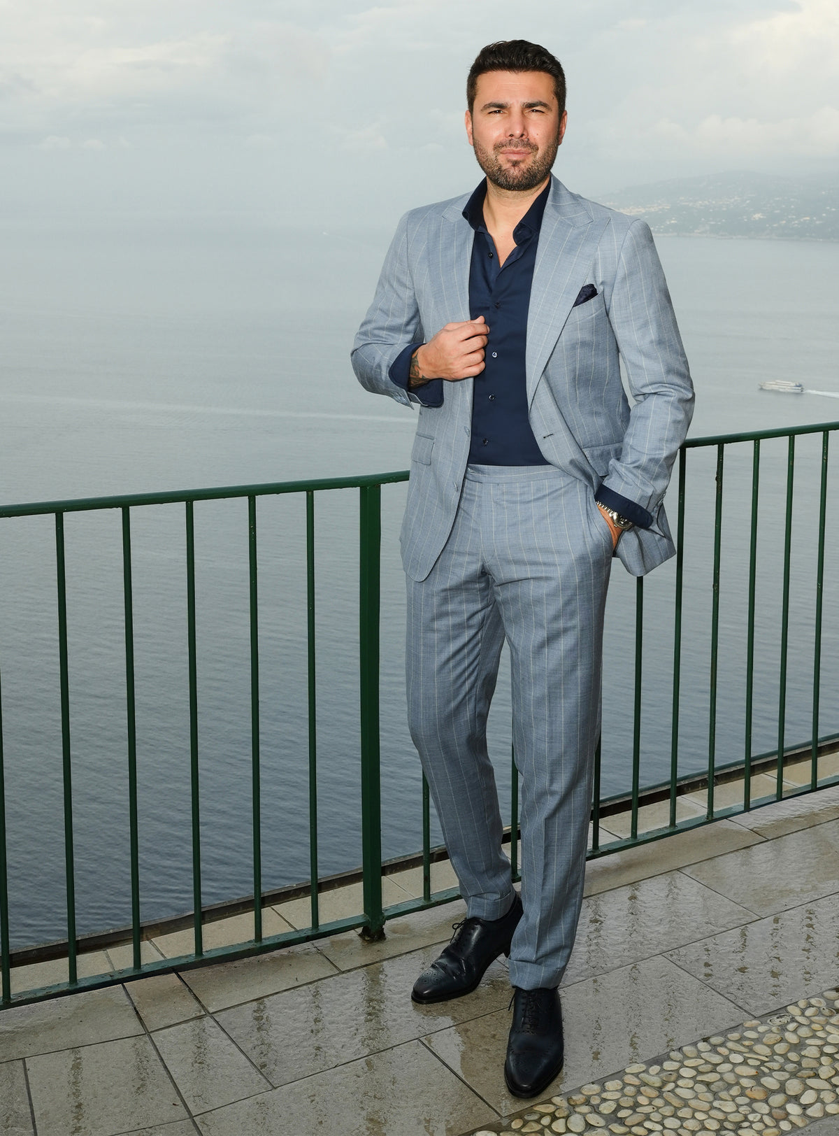 Blue-grey Consiglieri suit styled with a navy shirt and dark pocket square