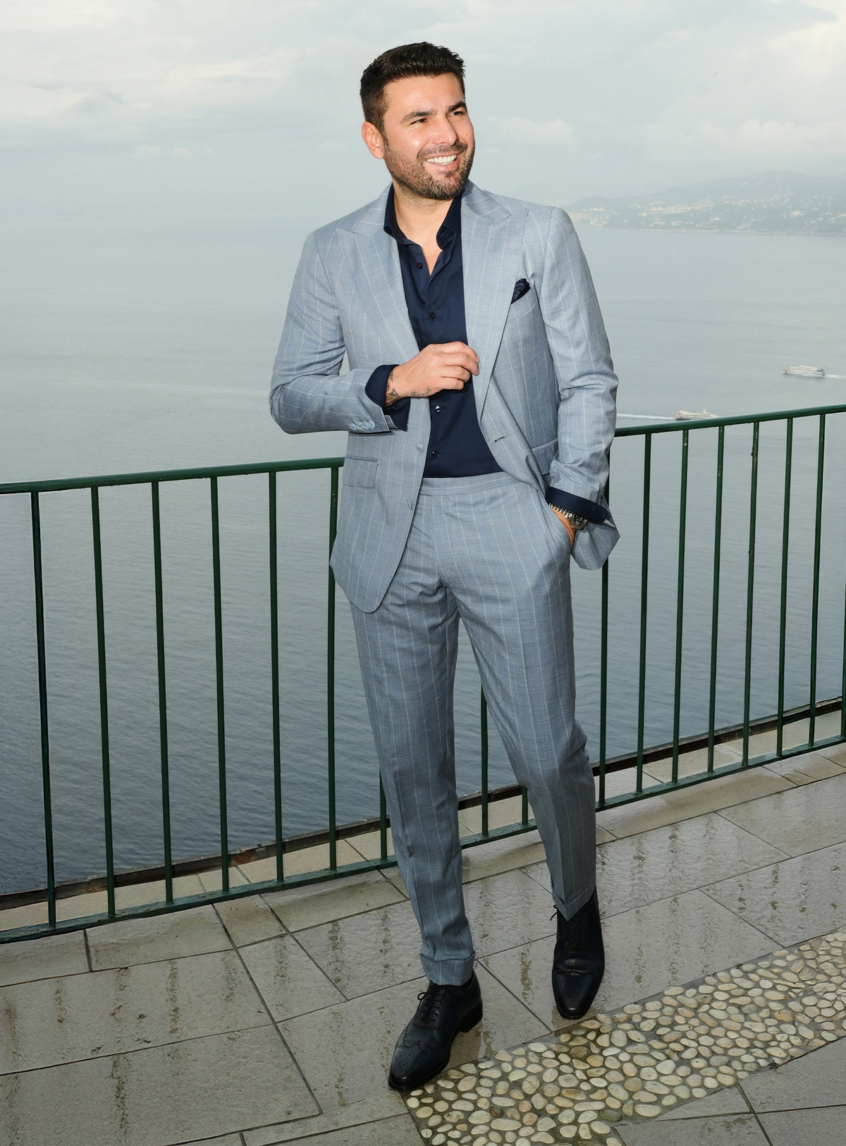 Blue-grey Consiglieri suit styled with a navy shirt and dark pocket square