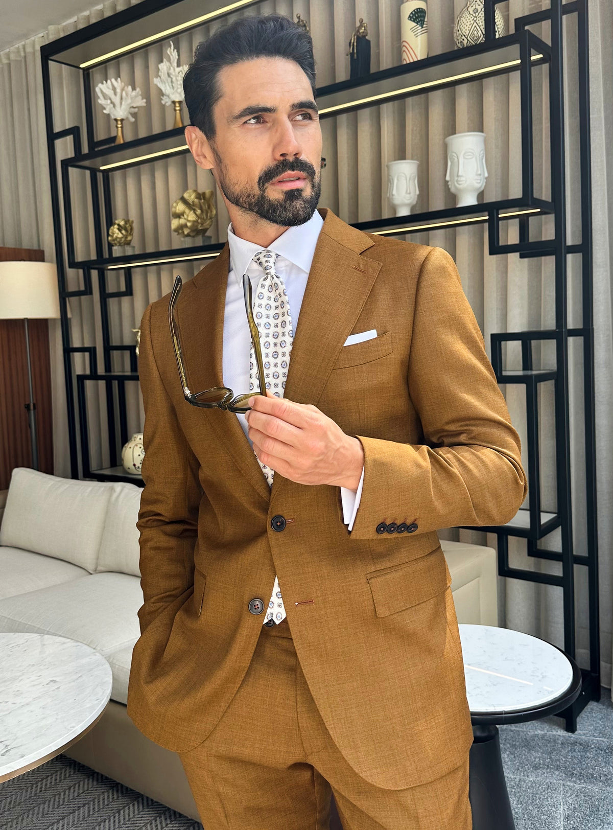 The ochre jacket of a Consiglieri look with a white pocket square and patterned accessory