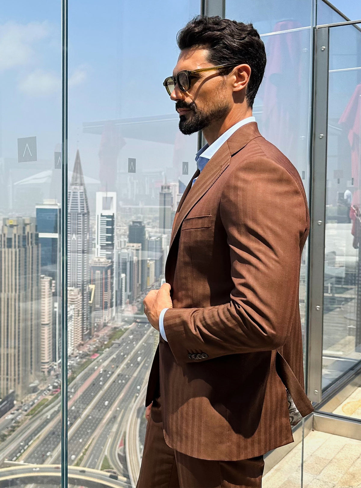 The side silhouette of a terracotta Consiglieri jacket worn with a pale blue shirt