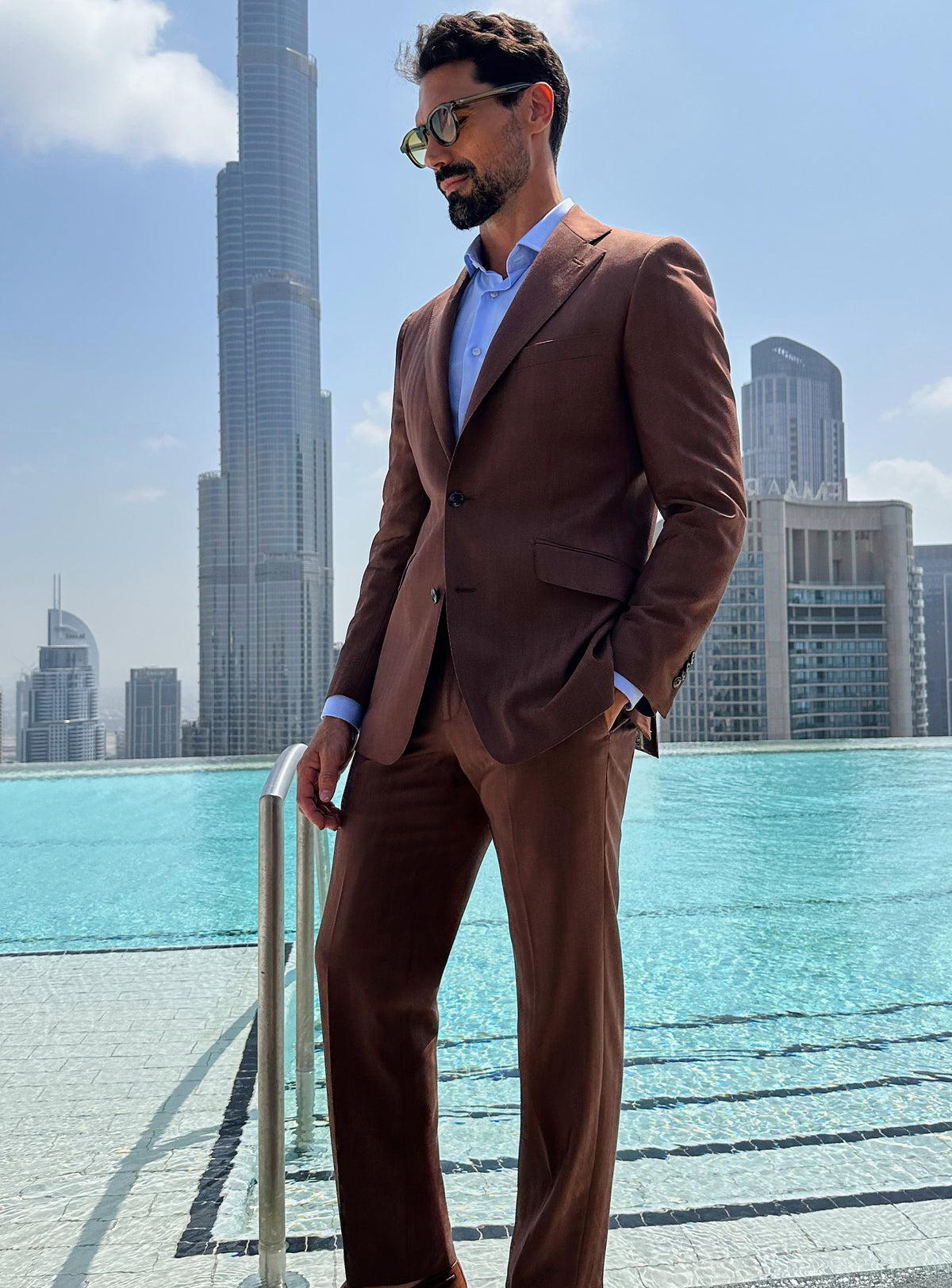Terracotta Consiglieri suit with a pale blue shirt and brown loafers