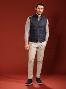 Navy quilted Consiglieri vest with a grey sweater and beige trousers