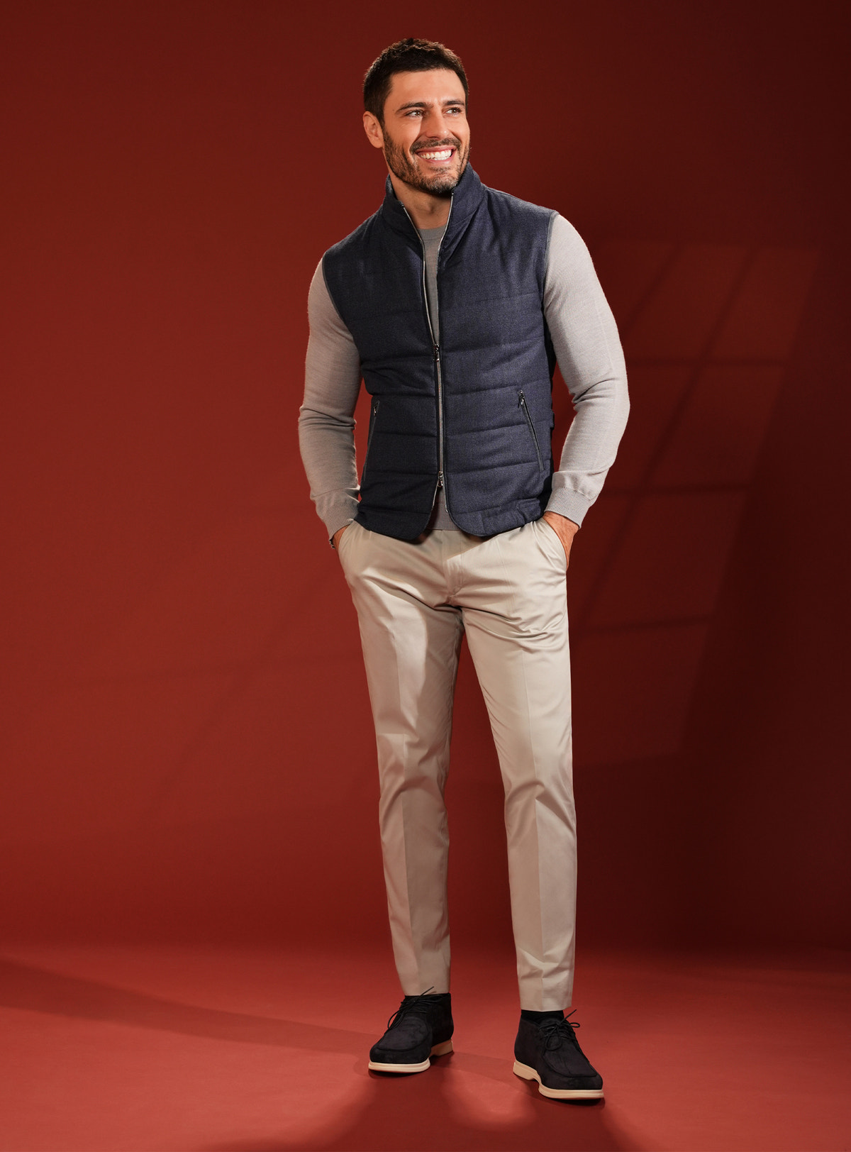 Navy quilted Consiglieri vest with a grey sweater and beige trousers