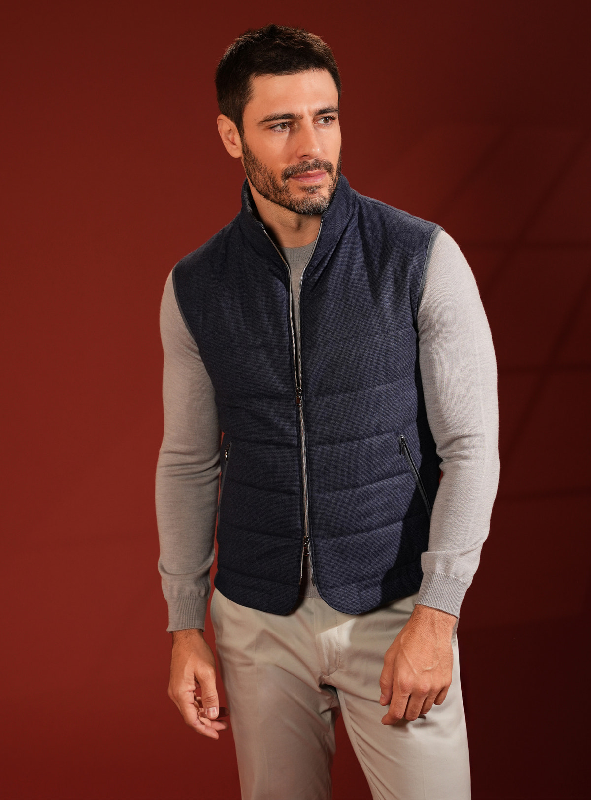 Navy quilted Consiglieri vest with a raised collar over a grey sweater