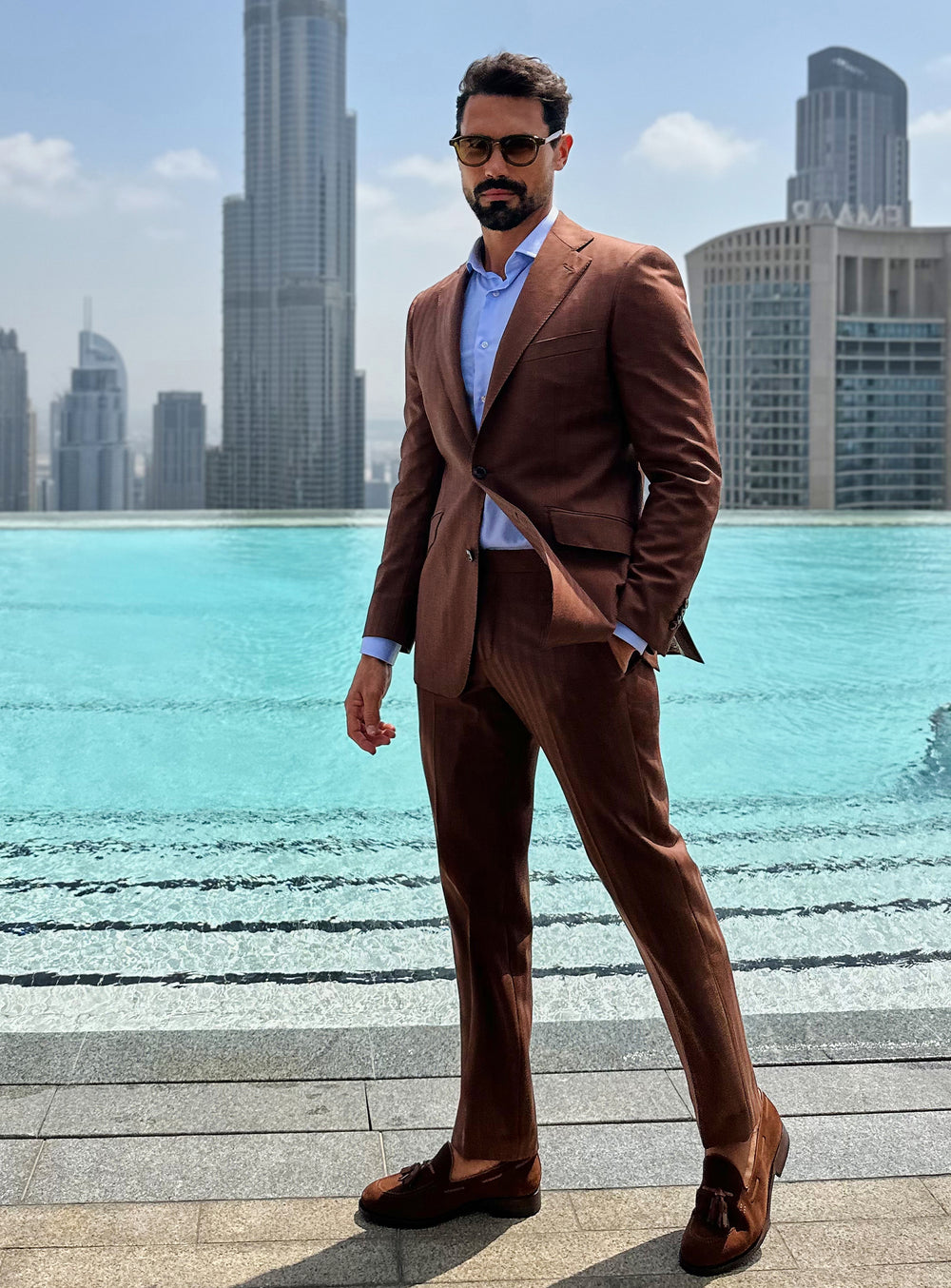Terracotta Consiglieri suit with a pale blue shirt and brown loafers