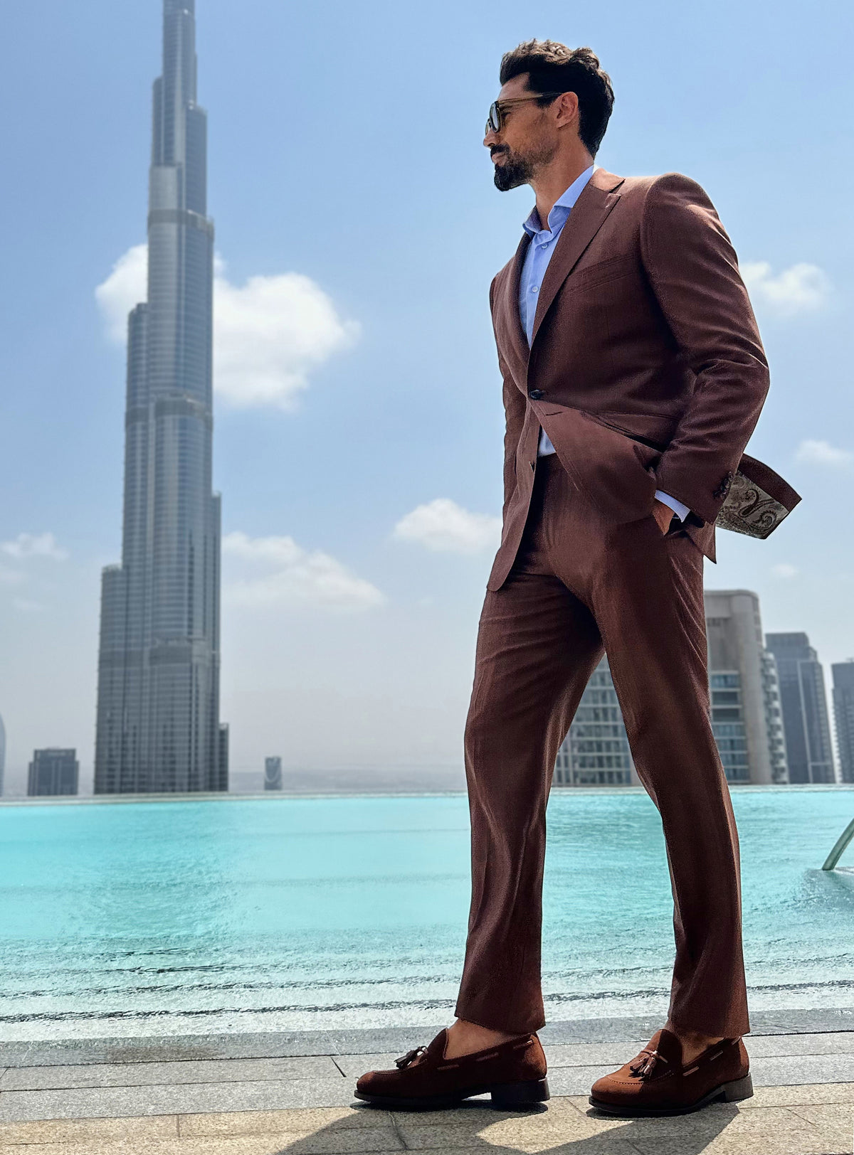 Terracotta Consiglieri suit with a pale blue shirt and brown loafers