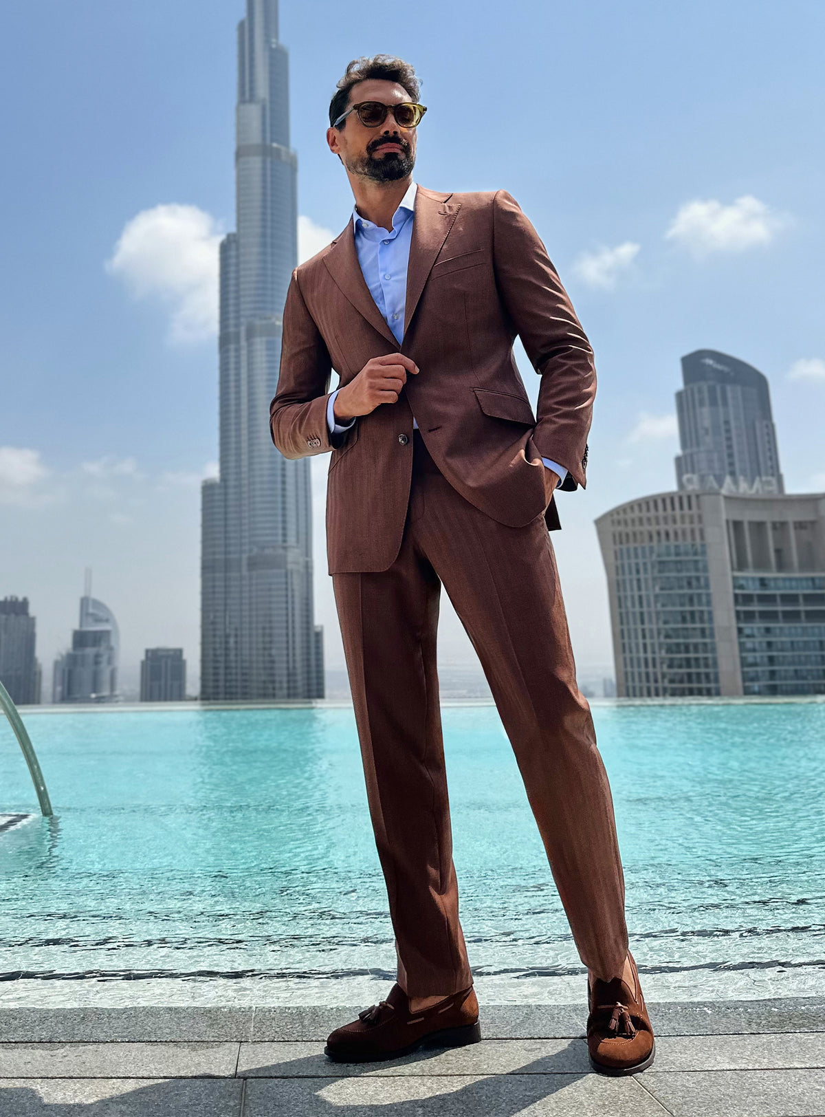 Terracotta Consiglieri suit with a pale blue shirt and brown loafers