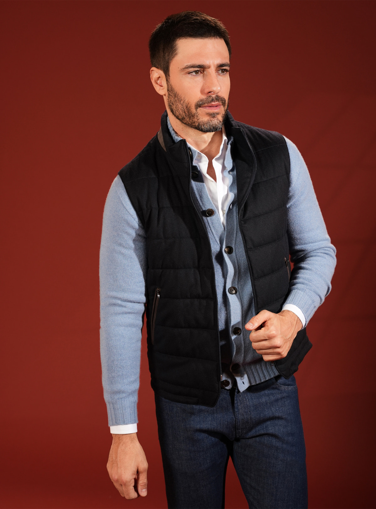 Black quilted Consiglieri vest worn over a pale blue cardigan