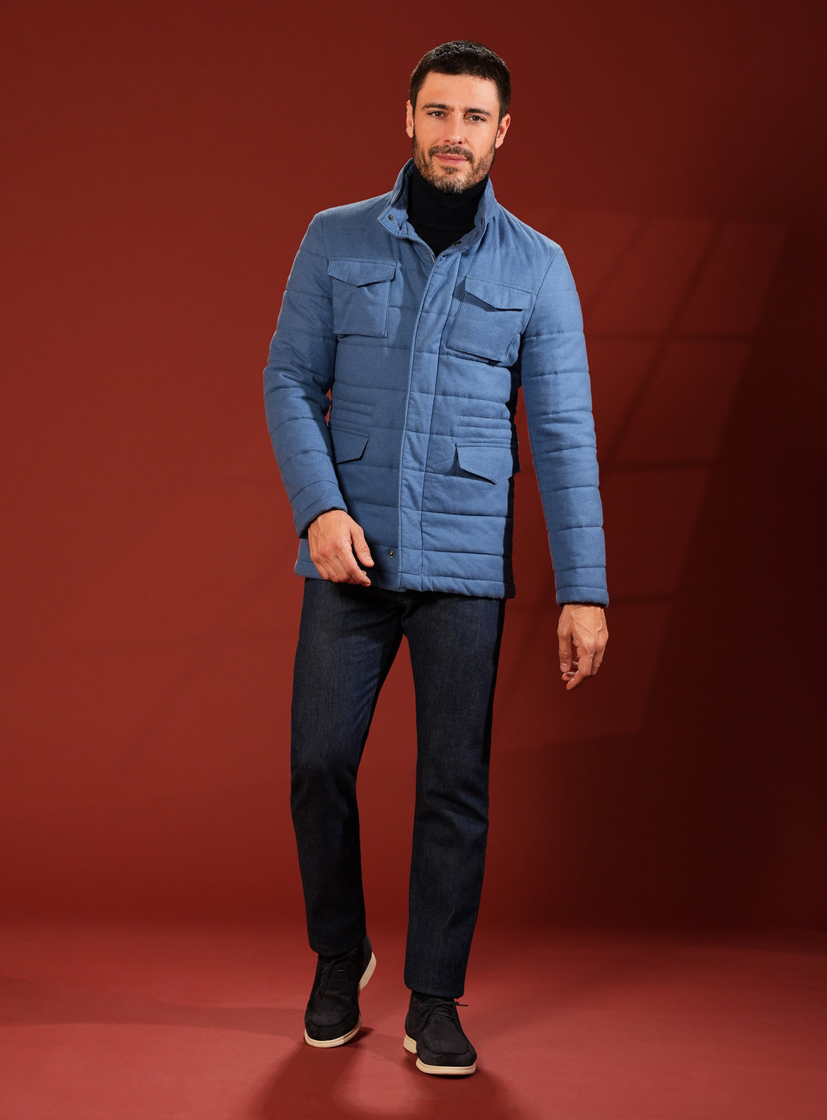 Blue quilted Consiglieri jacket with a dark turtleneck and trousers