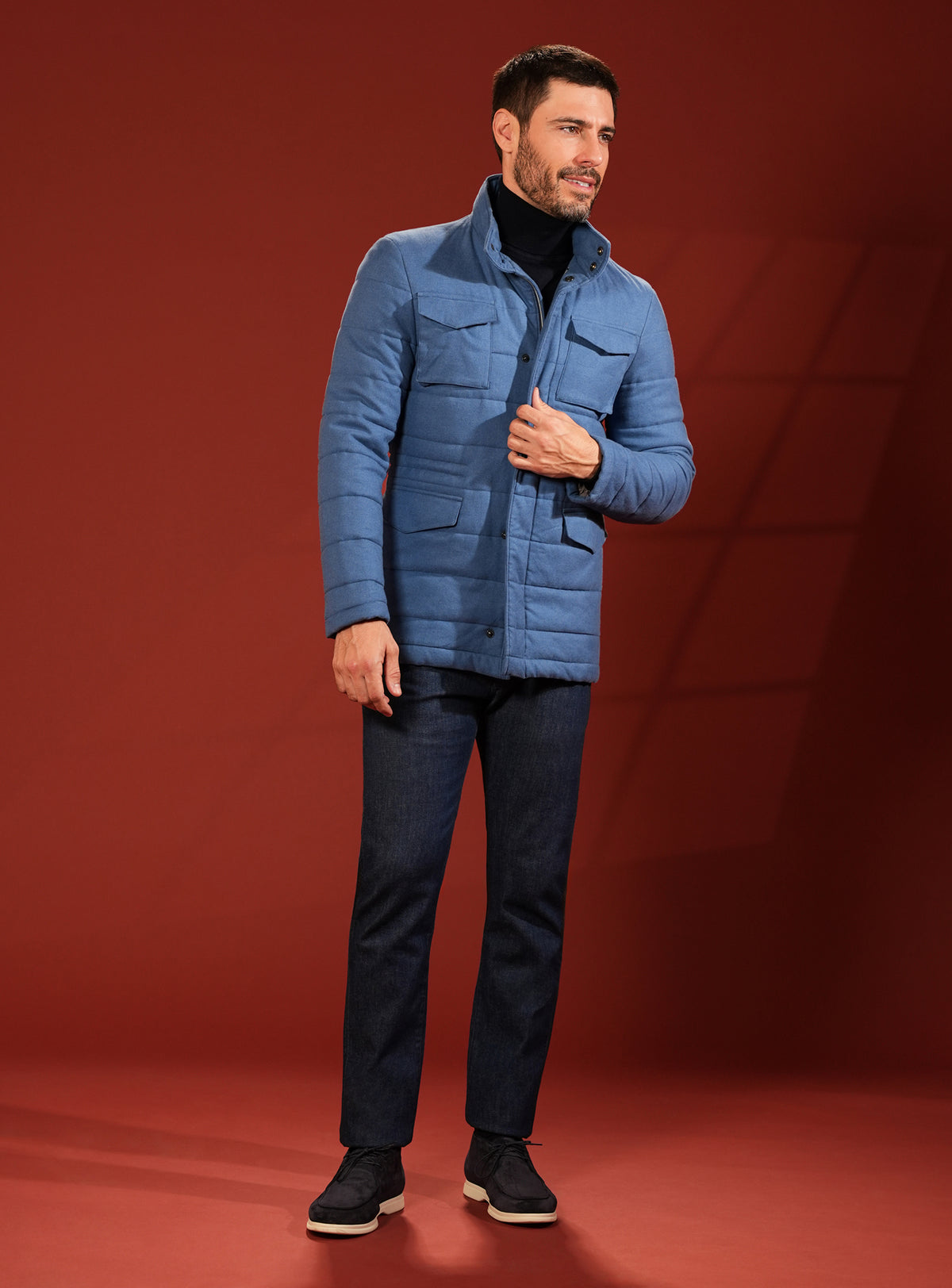 Blue quilted Consiglieri jacket with a dark turtleneck and trousers